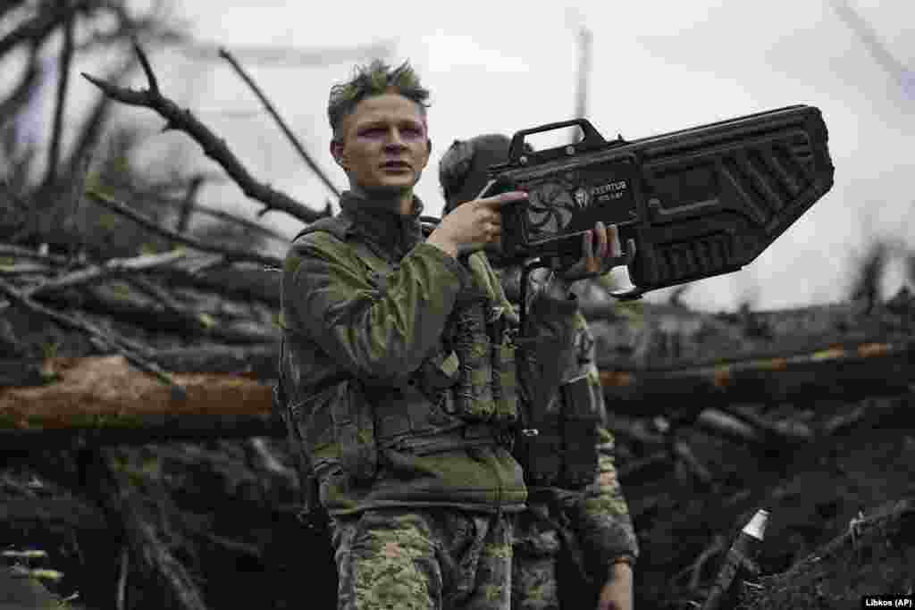 A Ukrainian soldier holds an anti-drone gun at a frontline position near Avdiyivka in April 2023. The $11,300 Ukrainian-made device seen in this image uses directed radio waves to overwhelm the connection between a drone and its operator. The interference can cut the drone’s video feed and, depending on the model of drone, can either force it to return to its takeoff point, land immediately, or drift away with the wind and eventually crash. 