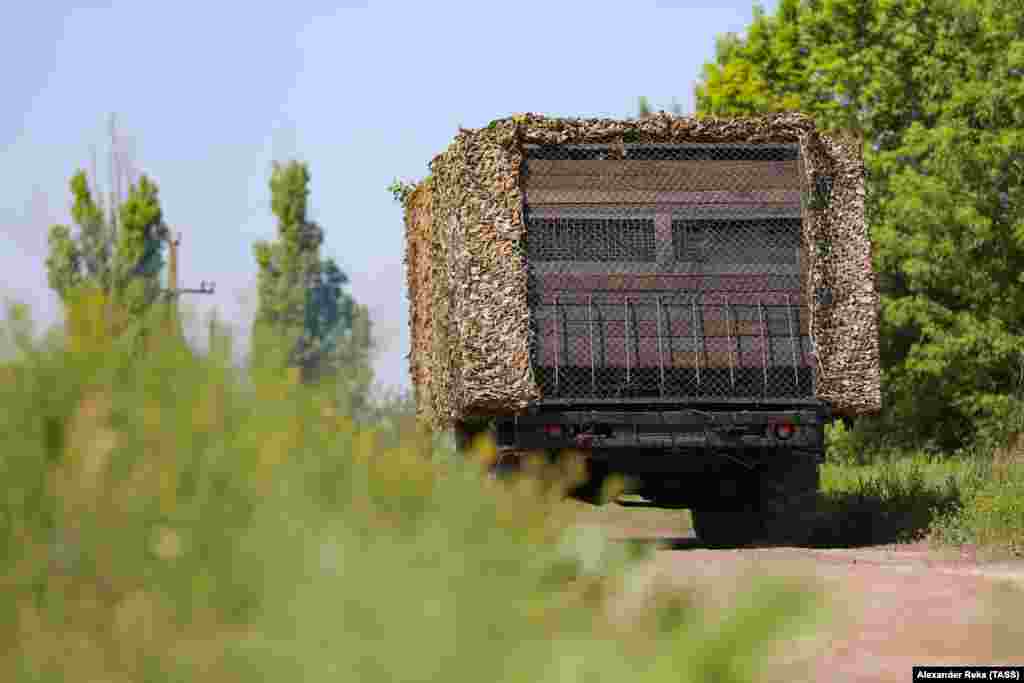 A Russian military vehicle fitted with makeshift wooden armor, netting, and apparent side armor to protect against FPV drones is seen in Ukraine's Luhansk region in June. 