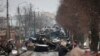 Жители города Буча рассматривают искореженные останки российской военной техники на дороге в сторону Киева. Украина, вторник, 1 марта 2022 года