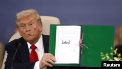 Trump arată un document privind armistițiul din Gaza, la Sharm-el-Sheik, pe 13 octombrie. În aceeași zi, a părut să sugereze că se va lansa din nou în eforturi de oprire a războiului din Ucraina.