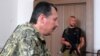 Self-proclaimed defense minister of the pro-Russian separatist "Donetsk People's Republic" Igor Strelkov (left) delivers a press conference as a fellow fighter looks on in Donetsk in July.