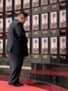 Ким Чен Ын стоит перед стелой с фотографиями военнослужащих Корейской народной армии (КНА), погибших на войне против Украины. Главный зал здания Центрального комитета Трудовой партии Кореи в Пхеньяне. 22 августа 2025 года