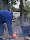 Ukraine - civilians with no access to gas or electricity build a fire in Kostyantynivka - screen grab