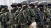 UKRAINE – Uniformed men, believed to be Russian servicemen, walk in formation near a Ukrainian military base in the village of Perevalnoye outside Simferopol, March 6, 2014