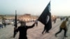 A fighter of the Islamic State of Iraq and the Levant (ISIL) waves an ISIL flag in the city of Mosul. The group has claimed wide swaths of territory in Iraq's north and west, including its second-largest city.