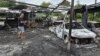 A resident stands next to burned cars at the site of a Russian drone strike on the Ukrainian city of Dnipro on July 26. 