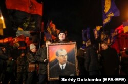 A woman holds a Stepan Bandera portrait during a rally of different nationalist parties to mark the 110th anniversary of his birth in Kyiv on January 1.