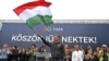 Lider partije Tisza, Peter Mađar, mađe mađarskom zastavom za govornicom, Budimpešta, 13. april 2025.