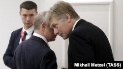 Президент России Владимир Путин и его пресс-секретарь Дмитрий Песков на саммите G20 в Осаке, 28 июня 2019 года 
