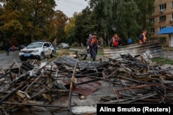 Radnici ukrajinskih komunalnih službi čiste ruševine u blizini zgrada oštećenih tokom ruskih napada dronovima i raketama u gradu Brovari, u blizini Kijeva, 10. oktobra 2025.