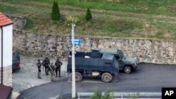 Na ovoj fotografiji koju je dostavila Kosovska policija, grupa naoružanih i maskiranih muškaraca stoji ispred Manastira Banjska u istoimenom selu na sjeveru Kosova, 24. septembra 2023. godine.