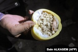Один из множества контейнеров с таблетками фенитиллина, найденных антиасадовскими повстанцами на подпольном предприятии по производству наркотиков на окраине Дамаска. 12 декабря 2024 года
